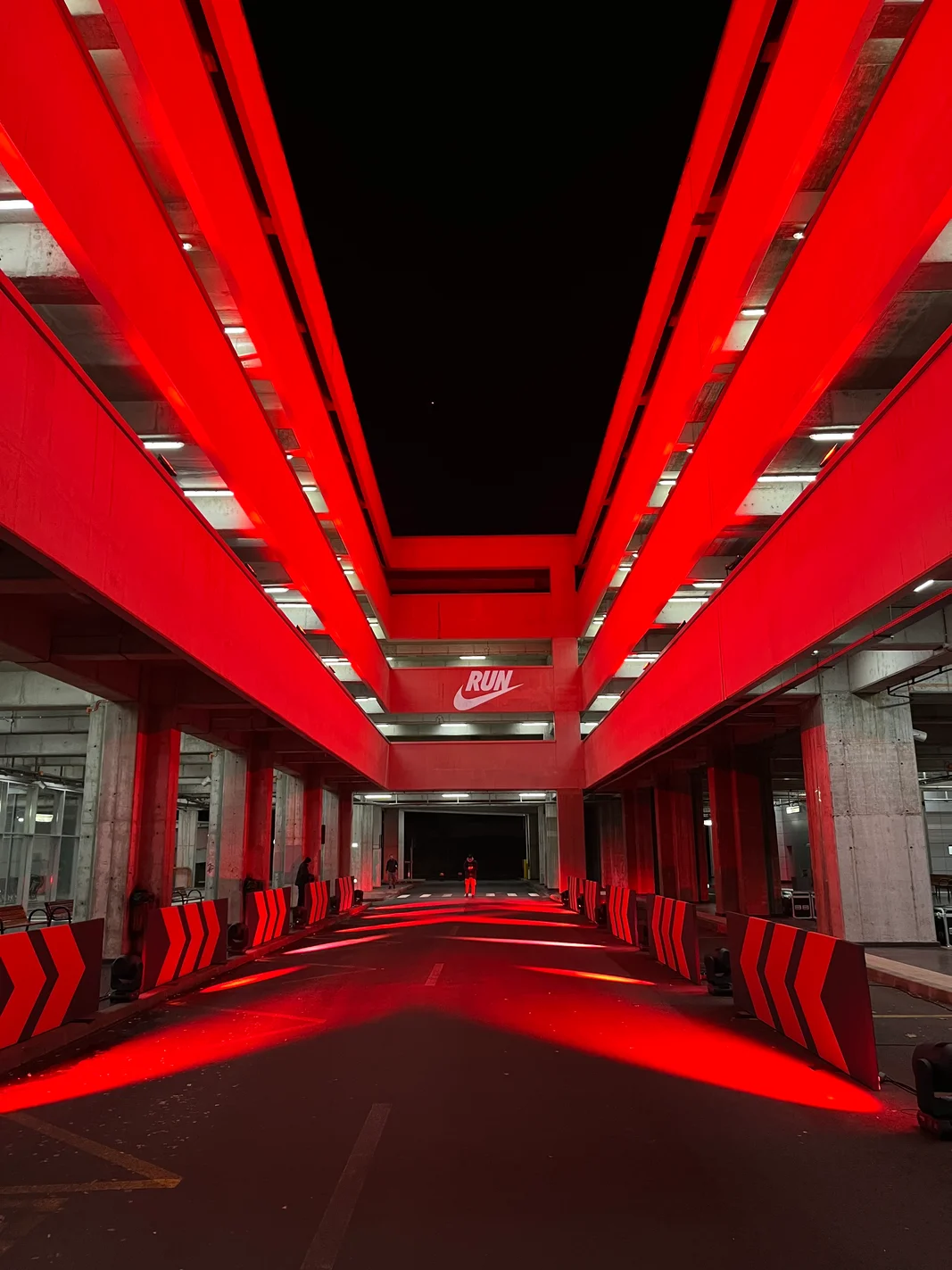 Red-lit parking garage course with a Nike Run projection at Nike Midnight Run in Bucharest